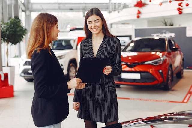 female-car-dealer-holding-a-contract