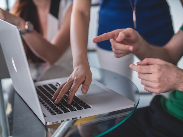 person-touching-and-pointing-macbook